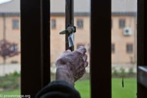 Older prisoner at his cell window